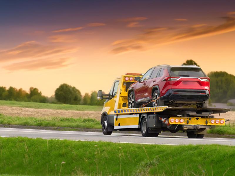 Kırmızı SUV taşıyan oto çekici